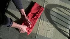 a person standing on top of a red piece of cloth