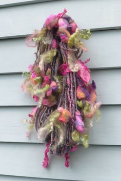 a multicolored scarf hanging on the side of a house