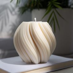 a white candle sitting on top of a table