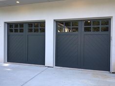 two garage doors are open in front of a white wall and grey concrete flooring