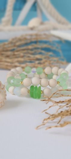 TitiTataStore.com Always FREE SHIPPING and a FREE GIFT! I Will Ship Within 24 Hours! Description: This listing is for a set of 2 Sea Glass Handmade Beach Bracelets.  Materials: 8mm Frosted Green Cultured Sea Glass Beads, 8mm Frosted White Cultured Sea Glass Beads, 8mm Matte Ivory Jasper Beads, 8mm Natural White Magnesite Beads, 8mm Matte Mystic Aura Quartz beads, 6mm Clear Mystic Aura Quartz beads, 8mm Natural Wood Beads, Green Cultured Sea Glass Pebbles Chips Beads, Gold tone Toho Glass Seed Be Coastal White Beaded Bracelets For Gift, Green Stackable Jewelry For The Beach, Beachy Green Jewelry For Beach Season, Green Beachy Jewelry For Beach Season, Green Friendship Bracelets With Round Beads For Vacation, Green Bracelets For Beach Season Gift, Handmade Green Bracelets For Beach, White Stackable Bracelets For Beach, White Stackable Beaded Bracelets For Beach