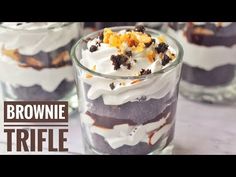 three desserts in glass cups with white frosting and brownie trifle on top