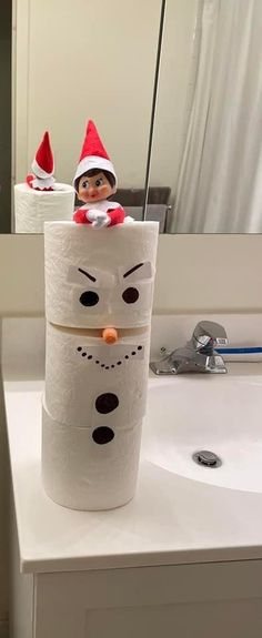 a toilet paper roll snowman sitting on top of a sink