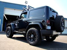 a black jeep parked in front of a garage