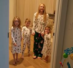 three girls in matching pajamas standing next to each other