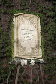 an old fashioned wedding sign with moss growing on it