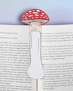 an open book with a red mushroom on it