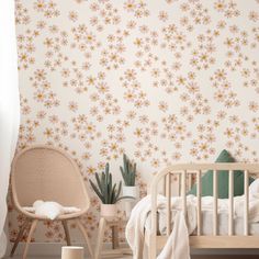 a baby's room with a crib, chair and wallpaper that has flowers on it