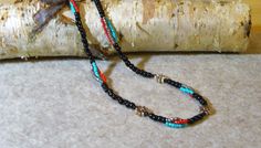 Southwestern Native American Necklace. Necklace is strung with turquoise, red and black glass beads and small silver colored flowers. Measures 22inchs. Southwestern Black Beaded Necklaces For Festivals, Southwestern Black Beaded Necklace For Festivals, Handmade Southwestern Black Beads, Southwestern Black Necklace With Colorful Beads, Black Southwestern Necklaces For Festivals, Black Southwestern Necklace For Festival, Handmade Southwestern Black Beaded Necklace, Southwestern Style Black Necklace For Festival, Southwestern Style Black Necklace For Festivals