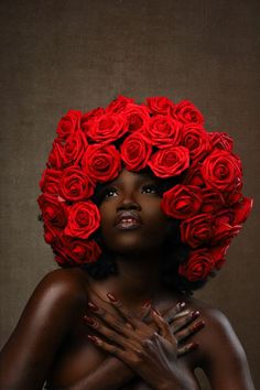 a woman with red roses on her head and hands in front of her face, posing for the camera