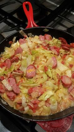 a pan filled with food sitting on top of a stove next to a red spatula