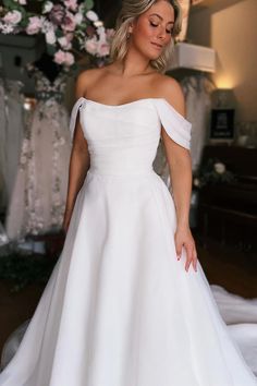 a woman in a white wedding dress posing for the camera