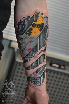 a man's arm with a train on it and yellow paint splattered