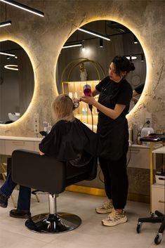 a woman is getting her hair cut at the salon