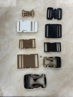 several different types of buckles on a white marble counter top with one open and two closed