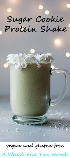 a green smoothie in a glass mug with coconut on top and the words sugar cookie protein shake