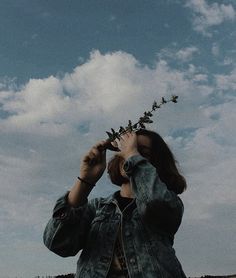 a woman looking up into the sky with her hands on her head