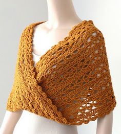 a crocheted shawl is shown on a mannequin