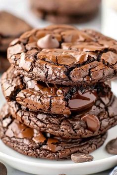 chocolate cookies are stacked on top of each other in the middle of a white plate