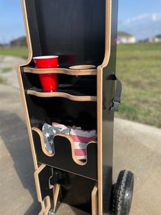 a skateboard that has some sort of storage unit on top of it, with two cups in the back