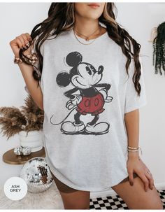 Step into the past with our "Inkwell Memories Mickey Tee." This vintage-inspired shirt captures the essence of classic Mickey Mouse in a sketch-style design. Embrace the nostalgia and show your love for the timeless charm of Disney's most iconic character. This tee is a must-have for any Disney enthusiast! *Unisex Sizing* Mickey Mouse Themed Crew Neck Shirt, Cotton Graphic Print Shirt For Disney Fan Events, Vintage Crew Neck T-shirt With Character Print, Pop Culture Graphic Print Shirt For Disney Fan Events, Vintage Crew Neck T-shirt With Cartoon Print, Vintage Cartoon Print Crew Neck T-shirt, Mickey Mouse Themed Cotton Top, Vintage Cotton T-shirt With Character Print, Retro White Top For Disney Fan Events