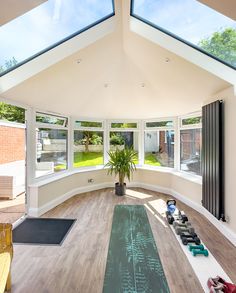 a large room with lots of windows and yoga mats on the floor