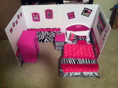 a doll house with zebra print furniture and pink accessories on the bed, desk and chair