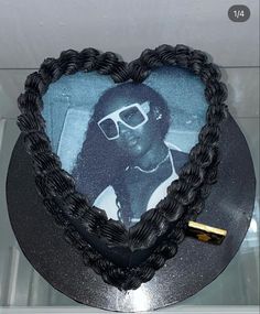 a black heart shaped cake with a photo on it