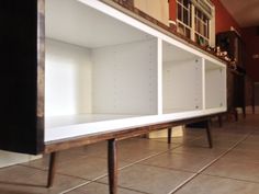 a white cabinet sitting on top of a tiled floor