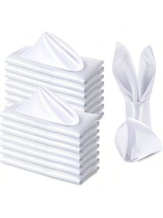 a stack of white napkins with a bow on the front and one in the back