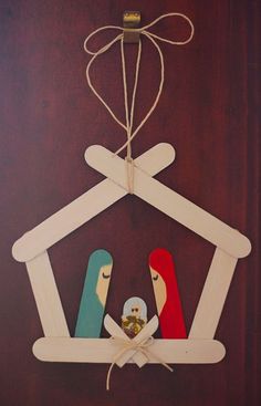 a nativity scene made out of popsicle sticks and wood, hanging on a wall