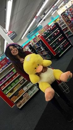 a woman holding a stuffed duck in a store