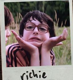 a polaroid photo of two children with their hands on their face