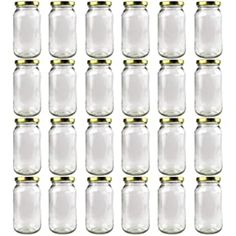 twelve glass jars with gold rims are lined up in the same row on a white background