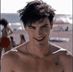 a man with no shirt on smiling at the camera