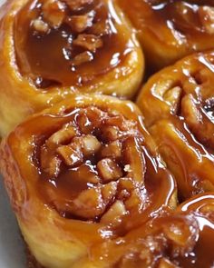 several cinnamon rolls with caramel sauce on top sitting in a white plate, ready to be eaten