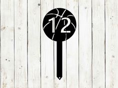 a black and white photo of a basketball on a wooden wall with the number twelve