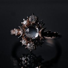 a close up of a ring on a black surface with diamonds and other things around it