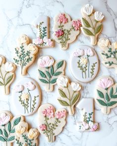 cookies decorated with flowers and leaves on a marble surface