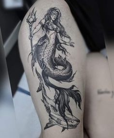 a woman with a mermaid tattoo on her thigh