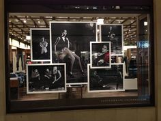 a window display with black and white photos on it's front glass, featuring mannequins