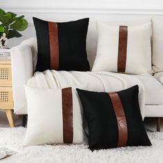 two black and white pillows sitting on top of a couch next to a white rug