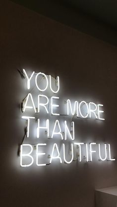 a neon sign that says you are more than beautiful on the side of a wall