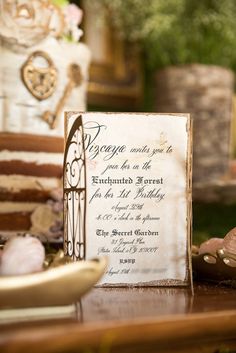 a wedding card sitting on top of a table next to a plate with cake in it