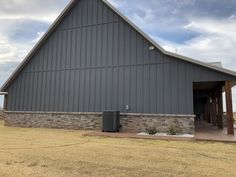 a large gray barn sitting on top of a dry grass field