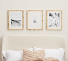 three framed pictures hang above a bed with white linens and pillows on the headboard