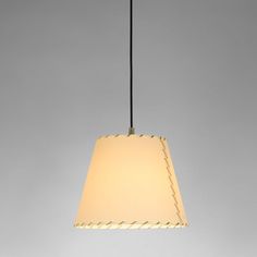 a white lamp hanging from a ceiling with a light shade on it's side