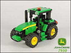 a green tractor with yellow wheels on a white background