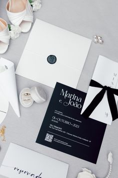 the wedding stationery is laid out on top of the bride's dress and shoes