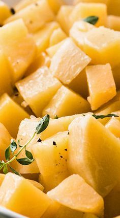 a white bowl filled with cut up pineapples and garnished with herbs